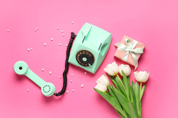 Retro telephone with beautiful tulips and gift box on pink background. International Women's Day - Photo, Image