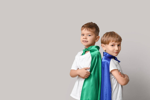 Cute małych chłopców przebranych za superbohaterów na szarym tle - Zdjęcie, obraz