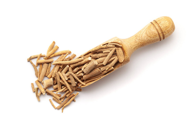 Top view of Organic Dry Ashwagandha (Withania somnifera) roots, in a wooden scoop. Isolated on a white background. - Photo, Image