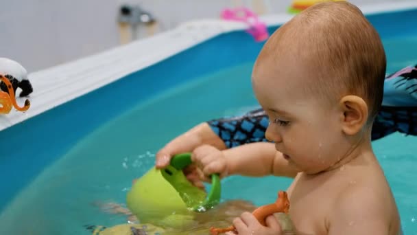 Das Kind schwimmt im Pool, lächelt, blickt in die Kamera. Schwimmunterricht - Filmmaterial, Video