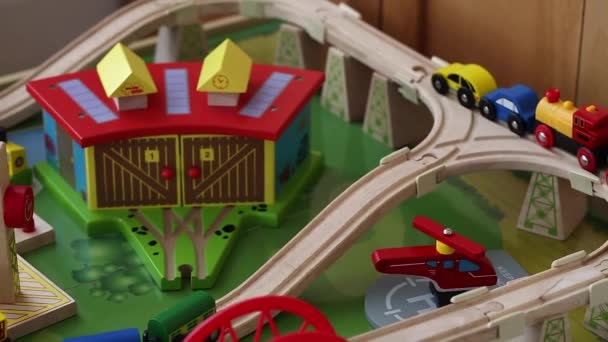 boy playing with toy trains and cars on track - Video, Çekim