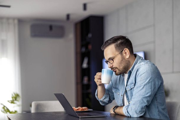 Homem usando laptop, escrevendo e-mail, reunião on-line ou pagamento online.Freelancer trabalhando em casa escritório. - Foto, Imagem