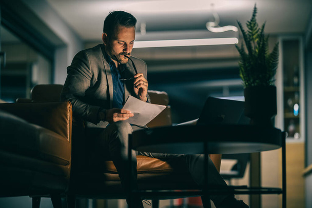 portret van een zakenman die 's avonds laat op kantoor werkt - Foto, afbeelding