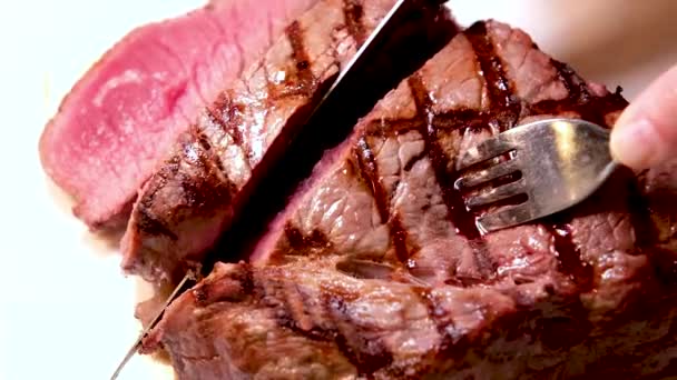 grill świeże mięso wołowe z krwawym stekiem serwującym pyszne jedzenie pokrojone nożem kilka filmów z jednego procesu gotowania pyszne steki bbq - Materiał filmowy, wideo