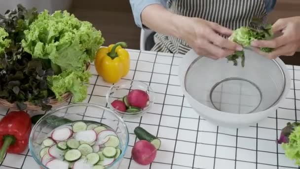 Над видом пожилого человека сортировки свежих овощей готовит свежий здоровый веганский салат на кухне. - Кадры, видео