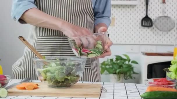 Unerkennbarer älterer Herr, der in der Küche Salat mit frischem Gemüse zubereitet. Gesunde Ernährung und Lebensstil. - Filmmaterial, Video