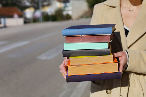 жінка тримає в руках стопку книг - Фото, зображення