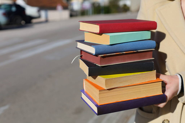 a person holding a stack of books in their hands - Photo, Image