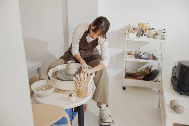 Profesional mujer artesana moldeando tazón de arcilla en el estudio de cerámica. Concepto de arte cerámico - Foto, Imagen
