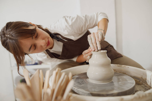 Profesjonalne żeńskie rzemieślniczki kształtujące glinianą miskę w pracowni garncarskiej. Koncepcja sztuki ceramicznej - Zdjęcie, obraz