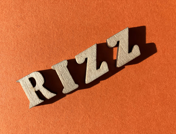 Rizz, сленгове слово для харизми, що використовується Gen Z, в лісистих літерних літерках ізольовані на яскраво-помаранчевому фоні - Фото, зображення