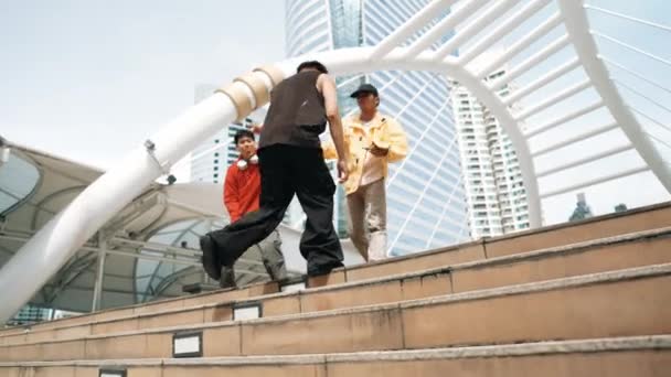 Diverse Hipster-Gruppen gehen die Treppe hinauf, während sie Street Dance aufführen. Attraktive asiatische Tänzerin, die mit einem multikulturellen Freund in der Stadt tanzt. Freier Stil, Lebensstil. Outdoor-Sport 2024. Schwungvoll. - Filmmaterial, Video