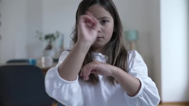 Una bambina che saluta NO con il dito indicando un chiaro rifiuto, X con le braccia guardando la fotocamera - Filmati, video