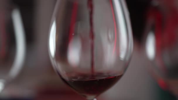 Наливаючи червоне вино в склянку в повільному темпі. Вечірнє святкування, алкогольний напій помірковано - Кадри, відео