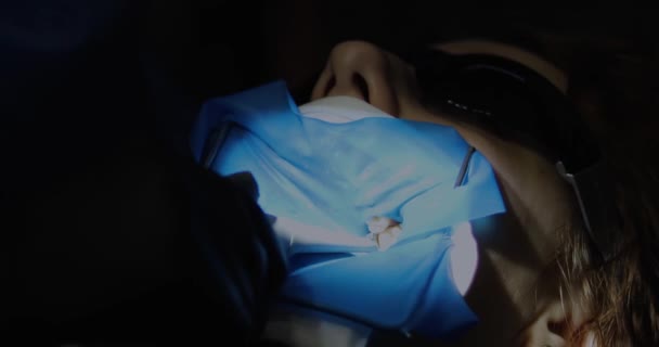 стоматологічна фотополімерна лампа для фіксації пломб, що світяться на пацієнта - Кадри, відео