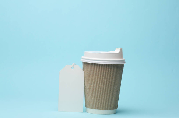 Taza de café desechable con etiqueta prise aislada sobre fondo azul. Plantilla para branding - Foto, Imagen