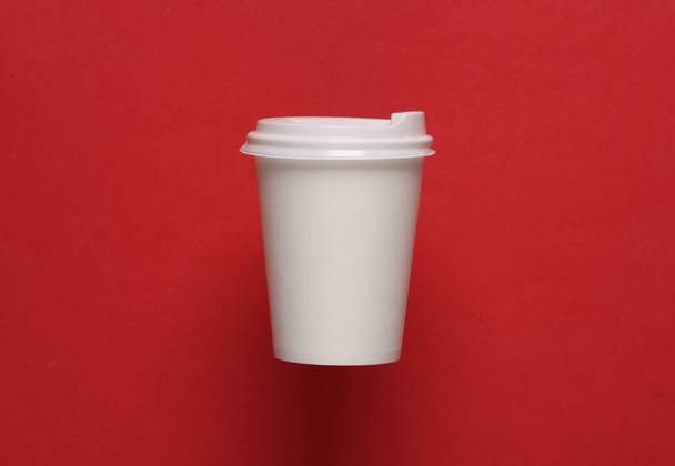 赤い背景にホットドリンク用の蓋付きホワイト使い捨てカップのモックアップ - 写真・画像