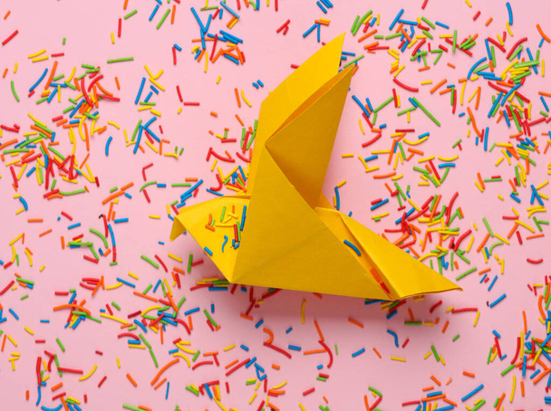 Renkli paskalya şekeri ya da pembe arka planda origami güvercini olan kek süslemeleri. - Fotoğraf, Görsel