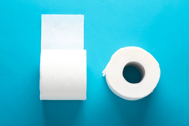 Δύο ρολά λευκού χαρτιού υγείας σε μπλε φόντο με σκιά - Φωτογραφία, εικόνα