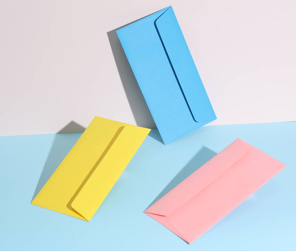 Творческая компоновка с цветными конвертами на пастельном ярком фоне. Минимализм - Фото, изображение