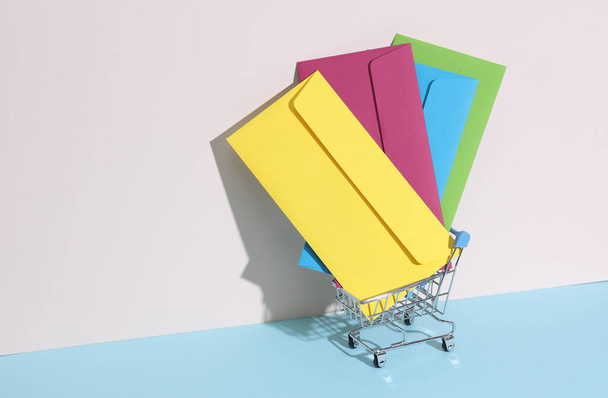 Kreativní rozložení s barevnými obálkami v mini supermarketu vozíku na pastelově jasném pozadí. Minimalismus - Fotografie, Obrázek