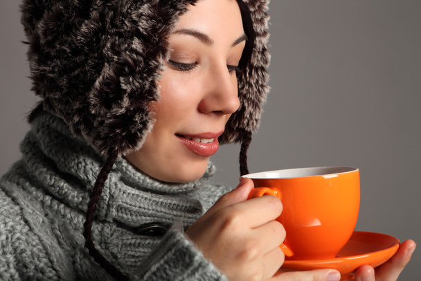 Young woman in warm winter hat drinking hot tea - Foto, immagini