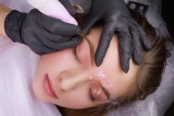 Injektion von permanentem Make-up in den Schwanz der Augenbraue. PMU-Verfahren, Permanentes Augenbrauen-Make-up. - Foto, Bild