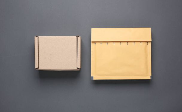Parcel cardboard box and envelope on a dark background. Top view - Photo, Image