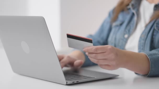 Μια κοντινή πελάτισσα, εξετάζοντας τα προϊόντα στην ηλεκτρονική οθόνη ενός laptop, χρησιμοποιεί με επάρκεια διάφορες μεθόδους πληρωμής για να εξασφαλίσει την ασφάλεια των συναλλαγών της στο ηλεκτρονικό κατάστημα. Πνευματική - Πλάνα, βίντεο