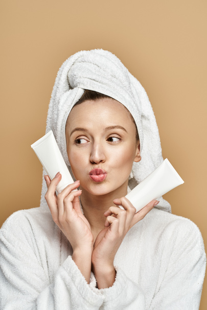 Een aantrekkelijke vrouw met natuurlijke schoonheid wikkelt een handdoek rond haar hoofd vredig. - Foto, afbeelding