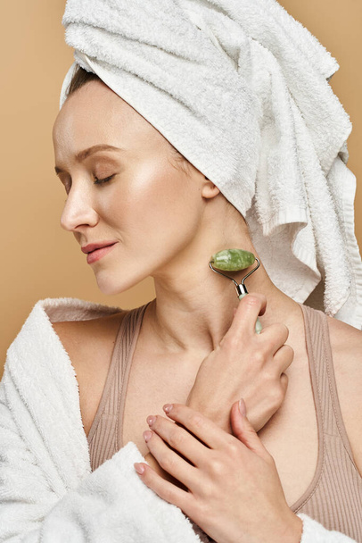 Μια ξαπλωμένη γυναίκα με μια πετσέτα απαλά τυλιγμένη γύρω από το κεφάλι της, αναδεικνύοντας φυσική ομορφιά και χάρη. - Φωτογραφία, εικόνα