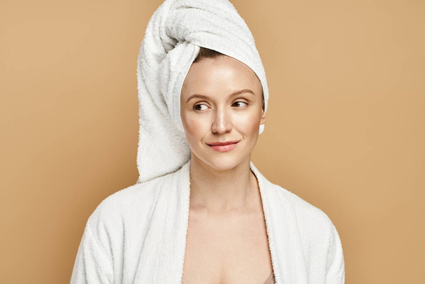 Uma mulher bonita com uma toalha enrolada em torno de sua cabeça, exalando beleza natural e serenidade. - Foto, Imagem