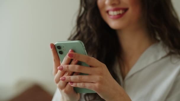 Akıllı telefon ekranını dinleyen gülümseyen kadın görüntüsü. Esmer bir kadın telefonundan haberlere bakıyor. Yüksek kalite 4k görüntü - Video, Çekim