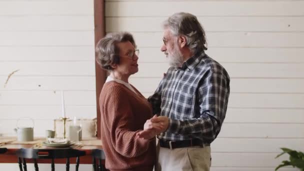 Προχωράτε. Ρομαντικό ζευγάρι της τρίτης οικογένειας γυναίκα και ο σύζυγος χορεύουν μουσική μαζί στην κουζίνα, χαμογελώντας γέλιο συνταξιούχος άνδρας και γυναίκα διασκεδάζοντας, απολαμβάνοντας ελεύθερο χρόνο μαζί στο σπίτι. Υψηλή - Πλάνα, βίντεο