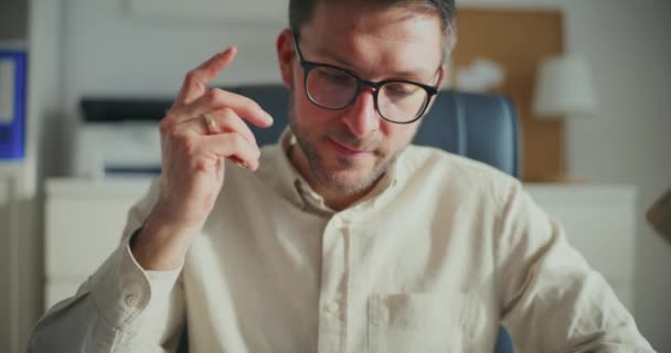 Mladý zaostřený podnikatel nosí brýle a pracuje v kanceláři - Záběry, video