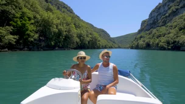 Férfiak és nők egy elektromos csónakban a Gorges Du Verdon-tó partján Franciaországban Provence-ban, a Sainte Croix Provence-i tó partján.,  - Felvétel, videó