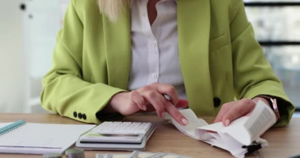 Business woman using calculator and checking financial report data in office. Revenues and budget of company and writes financial proposal - Footage, Video