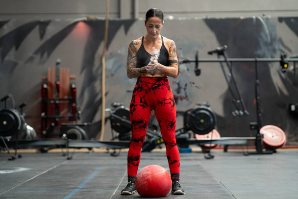 Strong woman ready to use a medicinal ball in a cross training gym - Photo, Image
