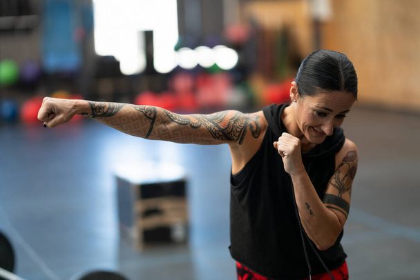 Close-up of a mature sportive woman practicing shadowboxing in a gym - Photo, Image