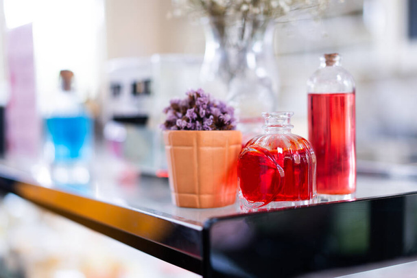 Bouteilles et bocaux en verre avec du jus rouge sur la table. - Photo, image