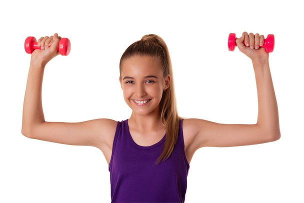 Υγιής γυμναστικής έφηβος κορίτσι κάνει ασκήσεις με αλτήρες απομονώνονται σε λευκό φόντο. - Φωτογραφία, εικόνα