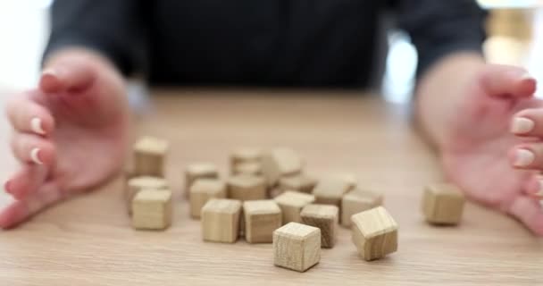Frauenhände gießen Holzwürfel auf den Tisch. Spiel und Logikrätsel für die Logik - Filmmaterial, Video