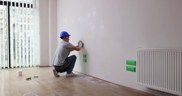 Sıvacı boyamadan önce duvarı zımpara kağıdıyla düzleştirir. Bir apartman dairesinde ya da evde kendin yap duvarını hizala - Video, Çekim