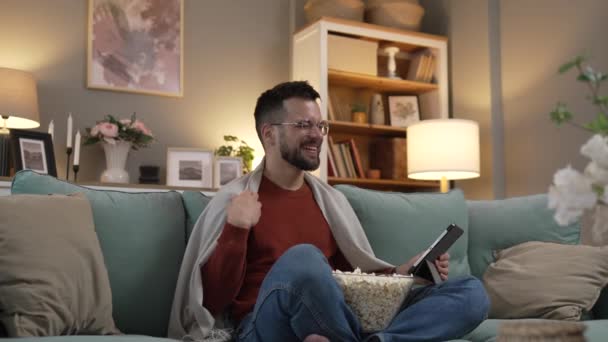 Один взрослый мужчина caucaian мужчина на диване кровати на домашнем видео смотреть кино онлайн использовать цифровой планшет - Кадры, видео
