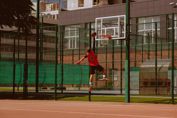 Чоловічий баскетболіст грає у стрітбол під час спекотного дня - Фото, зображення