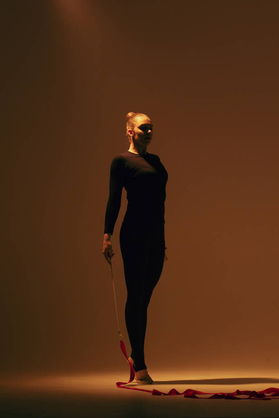 Gymnastique rythmique en action. Femme gymnaste rythmique dansant en studio. - Photo, image