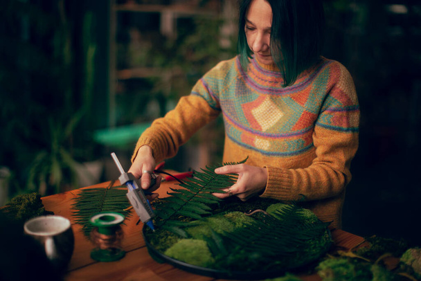 Mujer joven en taller haciendo juguetes de Navidad - Foto, imagen