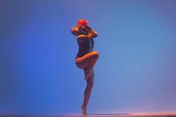Ritmikus torna akció közben. Ritmikus tornász nő táncol a stúdióban. - Fotó, kép