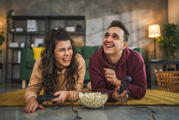 Aikuinen pari mies ja nainen valkoihoinen aviomies ja vaimo tai poikaystävä ja tyttöystävä pelata konsoli videopelejä kotona pidä joystick ohjain on hauskaa vapaa-ajan iloa ja liimaus käsite - Valokuva, kuva
