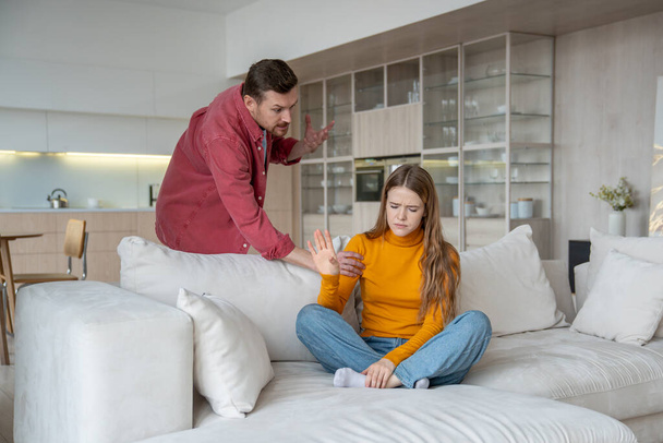 Home dispute couple engulfed in heated argument, tumultuous relationship with resentment, frustration. Angry man have quarrel dispute with offended woman in atmosphere charged with negative emotions. - Photo, Image